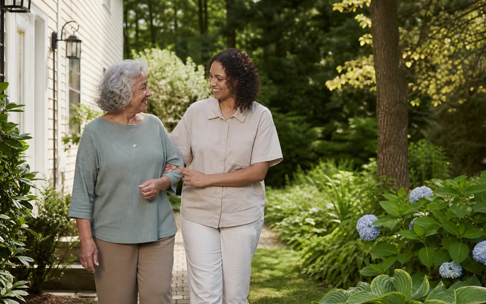 A senior caregiver walking with an older woman outside her home in Atlantic County, NJ
